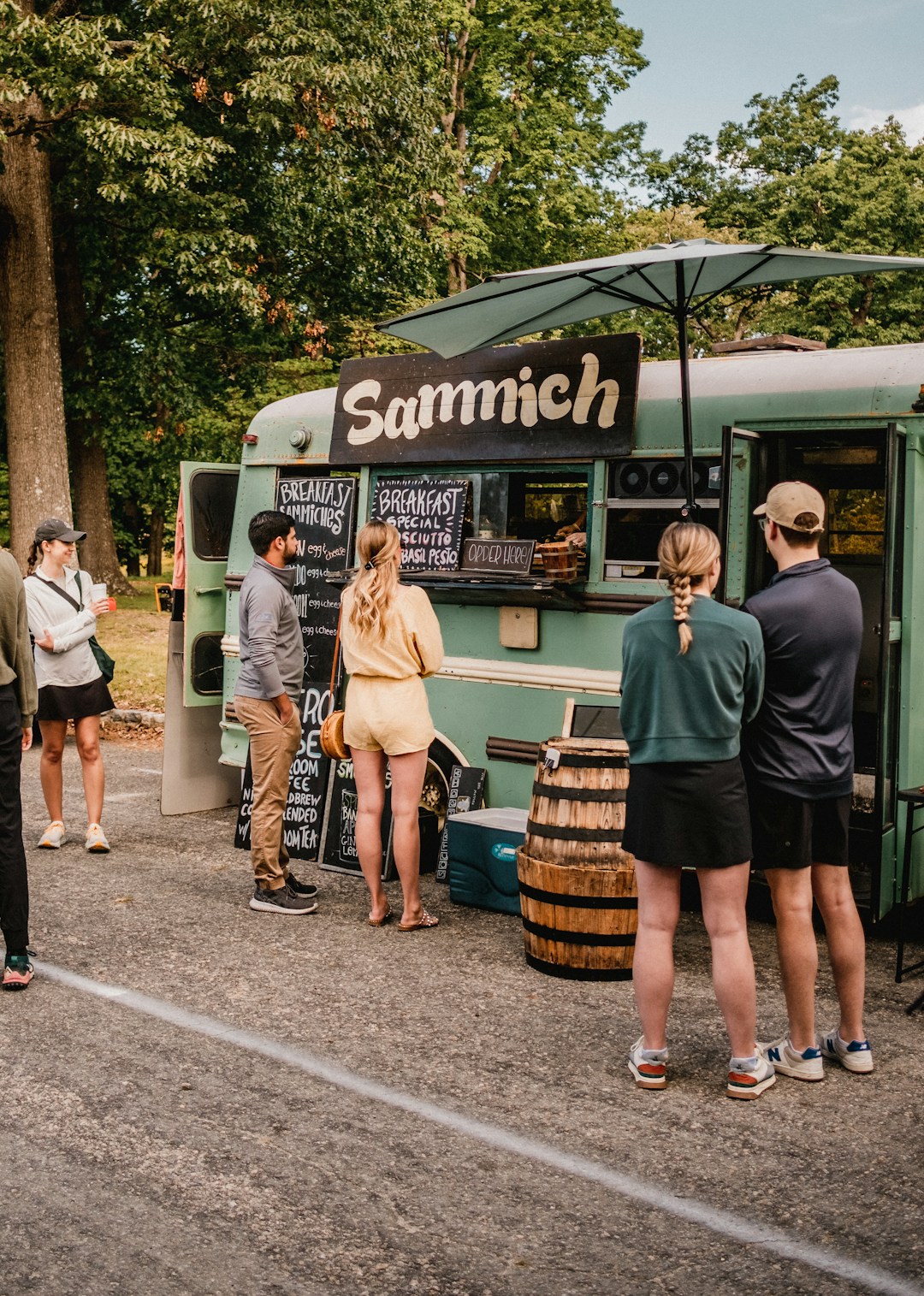 a group of people standing outside of a food truck