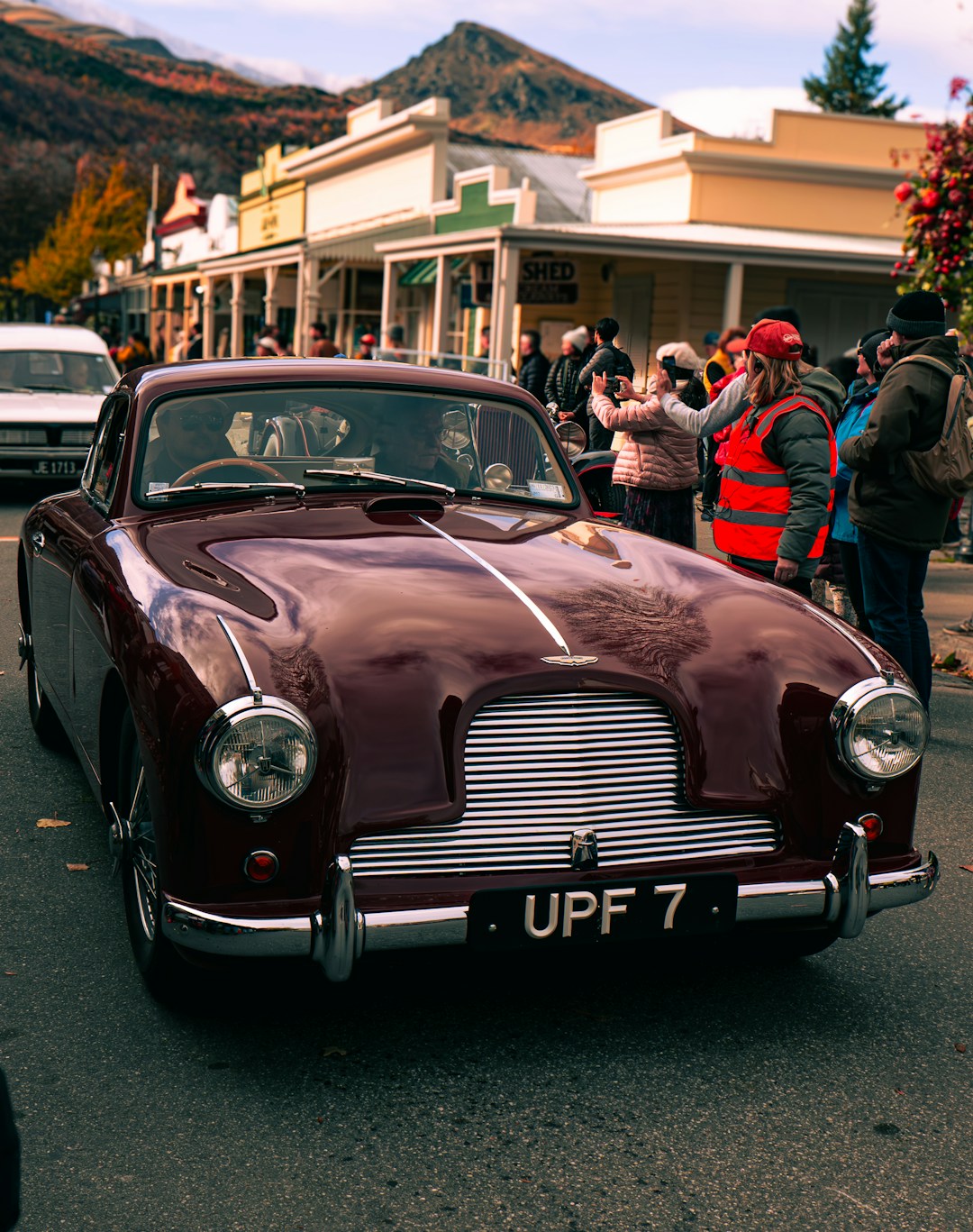 a maroon car parked on the side of the road